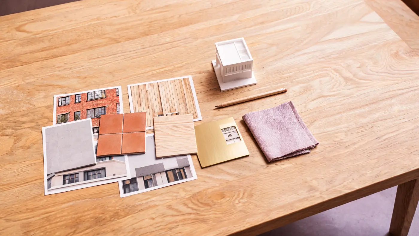 A mood board with photos of facades and material samples on a studio table.